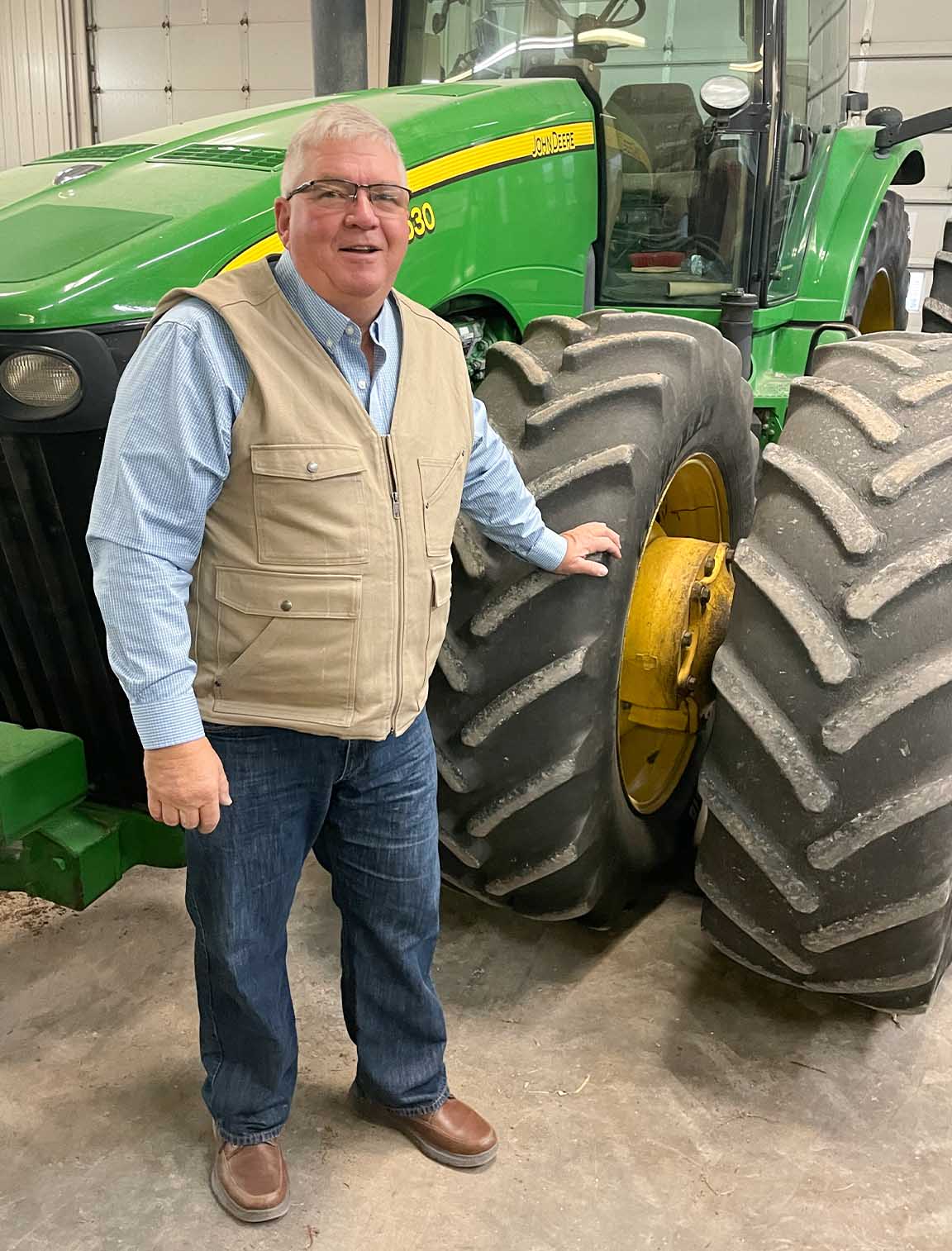 Farmer standing near John Deere tractor