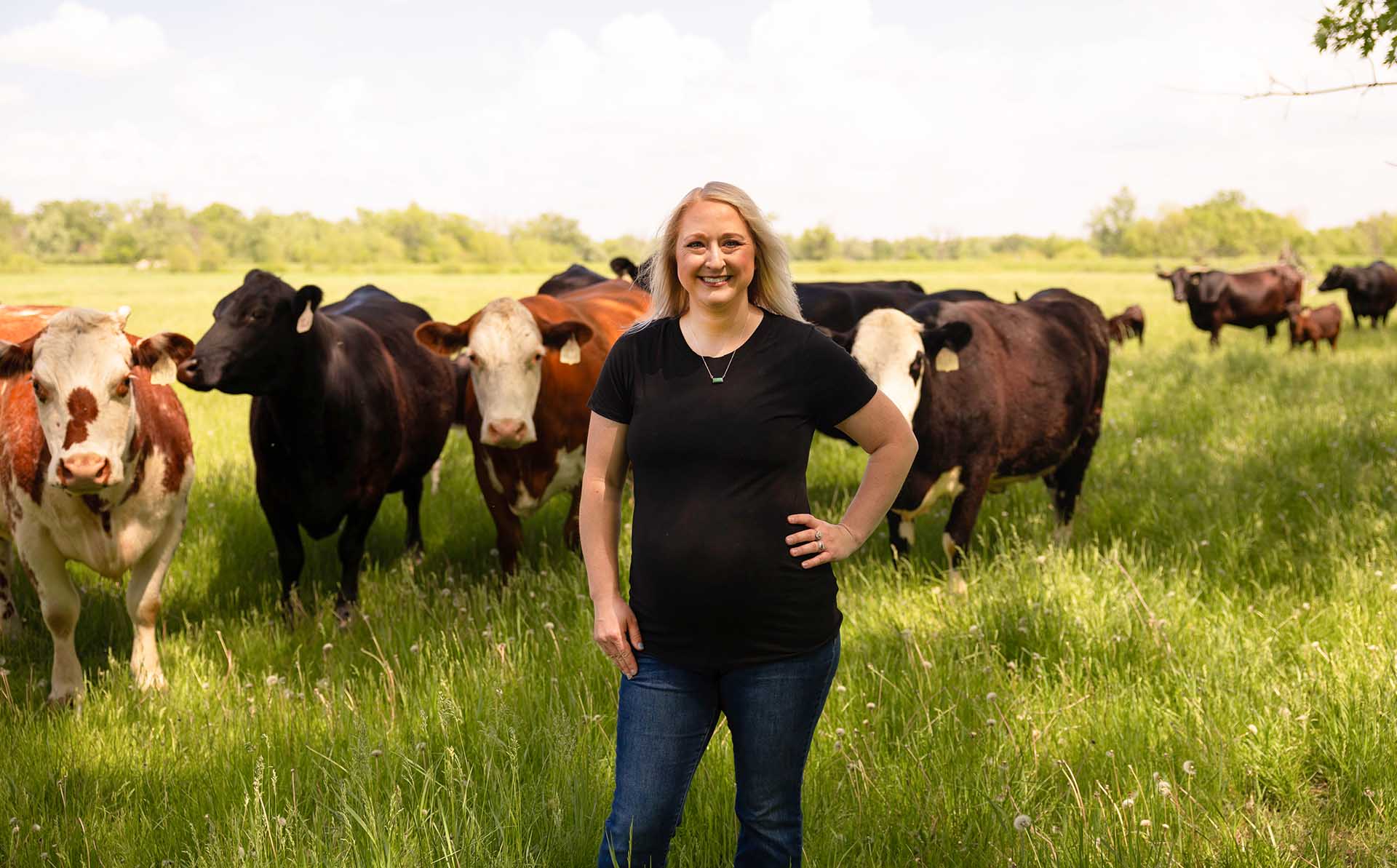 Farmer standing with cattle in pasture