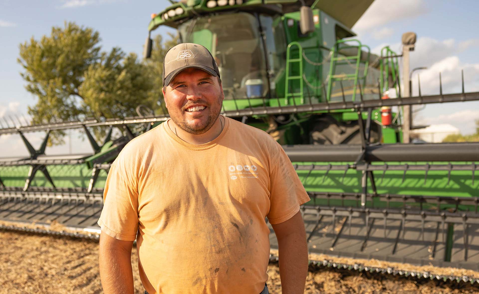 Iowa soybean farmer standing near combine