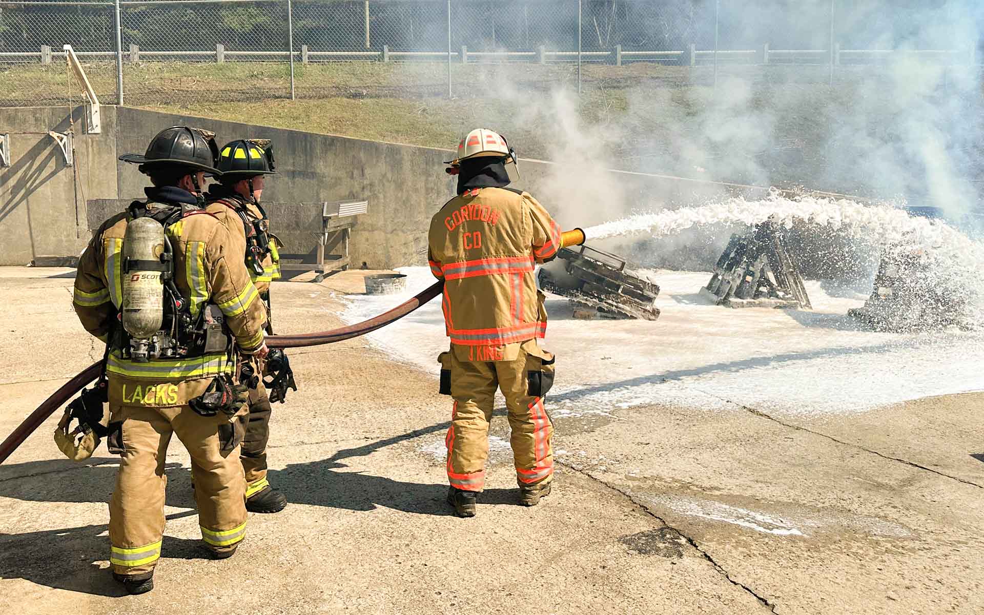 Firefighters spraying soy-based foam