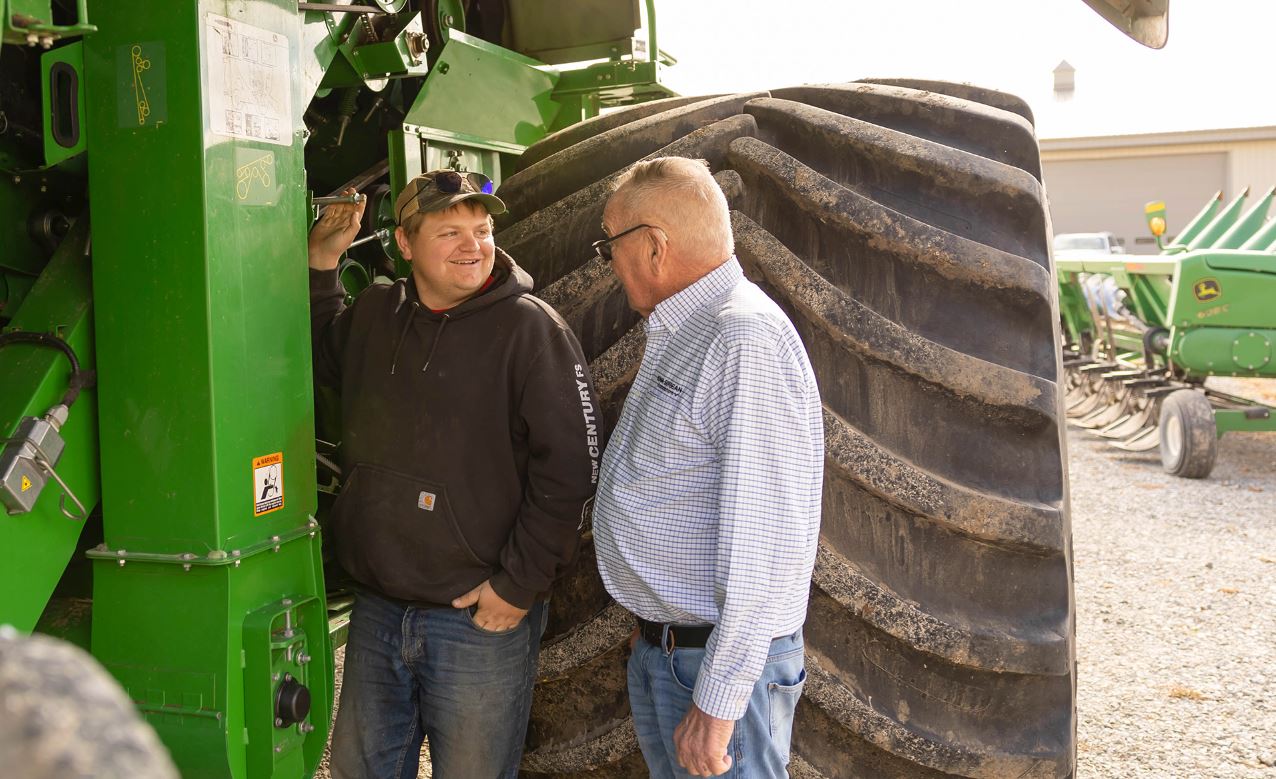 Farmer and his grandson by combine